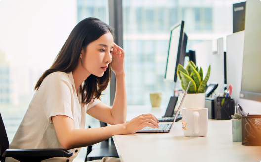 An individual using their laptop in the office.